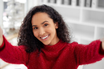 Wall Mural - Quick Christmas selfie. a young woman taking a selfie while celebrating Christmas at home.