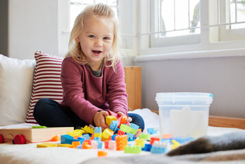 Wall Mural - Being creative with blocks. a little girl playing at home.