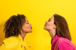 © ADDICTIVE STOCK - Happy multiethnic friends kissing each other on yellow background