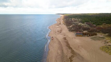 Canvas Print - Aerial view of a green beach by the sea with cloudy sly on the horizon