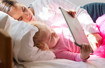 Wall Mural - Quality time with mom. a young mother and her daughter using a digital tablet together at home.