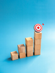 Poster - Goal and success. Arrow dart on 3d target icon on top of wooden cube blocks, bar graph steps, vertical. Business growth process, development, leadership, marketing, economic improvement concepts.