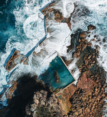 aerial view early morning light with ocean waves flowing over rocks around north curl curl ocean roc