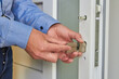 installing the lock cylinder in the door,young locksmith repairs doors in warehouse, office