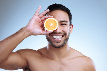 Poster - Destroy blemishes with a boost of vitamin C. Studio portrait of a handsome young man posing with an orange against a grey background.