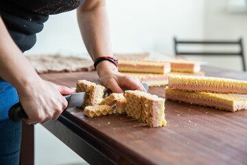 Sticker - Housewife in the process of preparing delicious wafer biscuit in the  kitchen - cutting into pieces