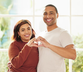 Sticker - Love lives in this home. a young couple standing inside together and making a heart-shaped gesture.