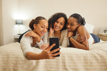 Poster - Spending some time with the girls. three girlfriends taking a selfie while lying on a bed together.