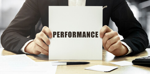 Poster - Businessman holding a white card with text PERFORMANCE on office background
