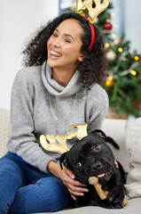 Sticker - Guess who got into the Christmas presents early. a young woman playing with her dog during Christmas time at home.