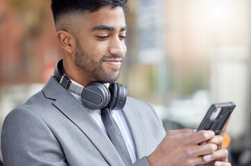 Poster - I like to start my day with a small game. a handsome young businessman standing in the city and using his cellphone.