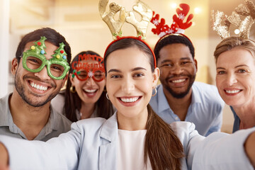 Spreading the festive cheer. Portrait of a group of businesspeople taking selfies together during a Christmas party at work.