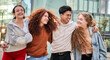 © CarlosBarquero - Portrait of group of four young students strolling happily around campus. Smiling friends and having fun together on sunny day outdoor. Cheerful college classmates hugging and laughing.