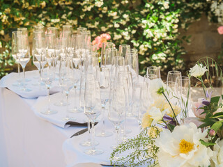 Wall Mural - Lots of empty glasses at wedding reception. Close-up of row glasses prepare service for outdoors dinner or event