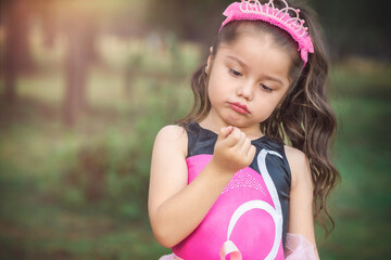 beautiful minor little girl playing in the park with ballerina costume laughing screaming with happiness in family enjoying children's day on train tracks