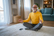 © Miljan Živković - Mature senior man practice guided meditation manifestation at home