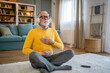 © Miljan Živković - Mature senior man practice guided meditation manifestation at home