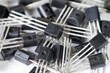Macro shot of large heap of bipolar transistors in case style TO-92 or TO-226 on a white background
