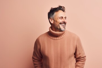 Wall Mural - Portrait of a smiling man in a sweater on a pink background