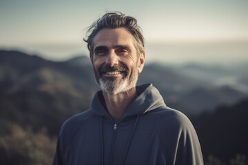 Poster - Portrait of a handsome middle-aged man smiling at the camera on top of a mountain.