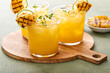 Grilled pineapple margarita garnished with lime wedges