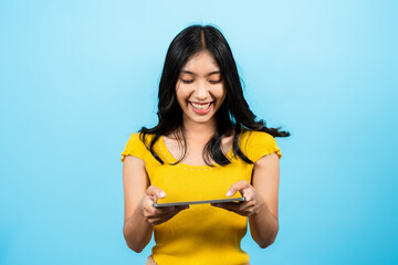 Portrait, Asian girl, was playing competitive game with friends on laptop very fun and it, causing laugh out loud, had very happy look in eyes, Isolated indoor studio on blue background.