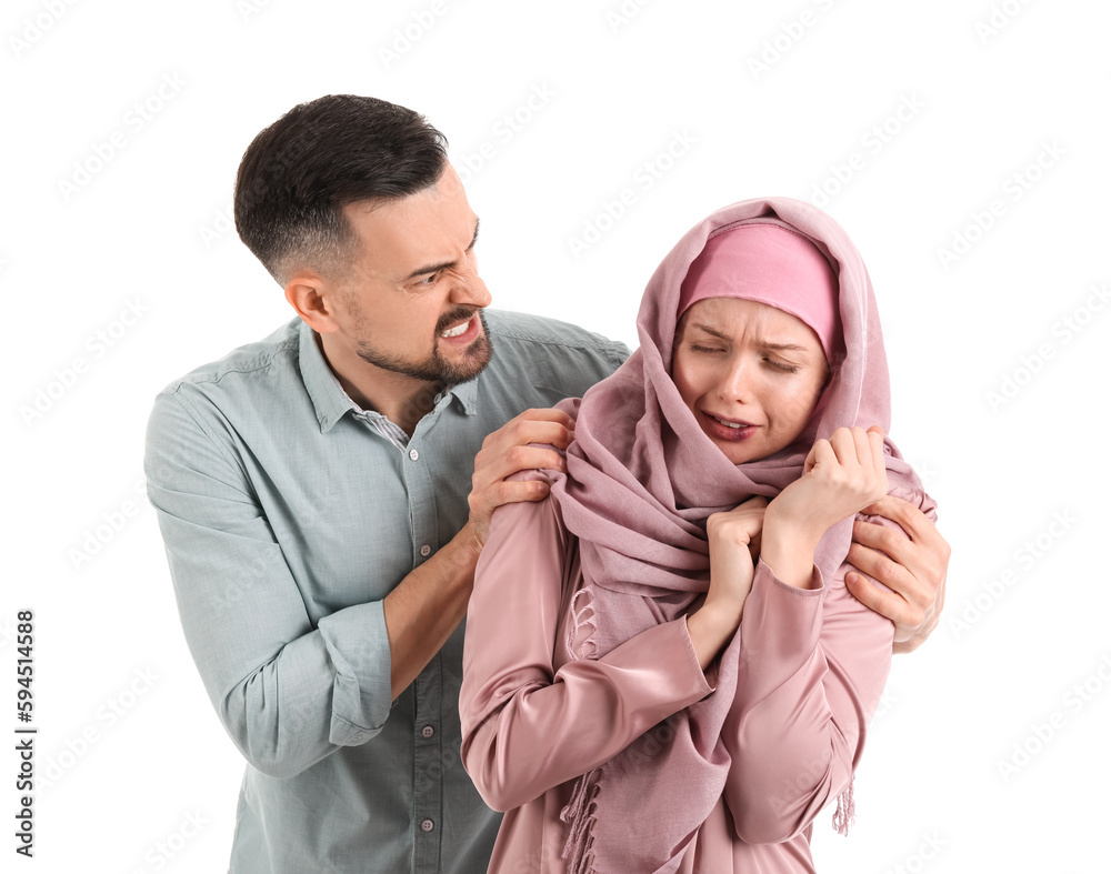 Angry Muslim man threatening his wife on white background. Domestic violence concept