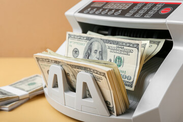 Sticker - Modern cash counting machine with dollar banknotes on color background, closeup