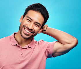 Poster - Smile, happy and portrait of Asian man on blue background with pride, confidence and happiness. Fashion, confident and face of isolated male in studio with style, relaxing and excited expression