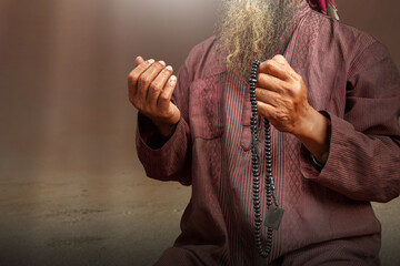 Poster - Muslim man with a beard wearing keffiyeh with agal praying with prayer beads on his hands