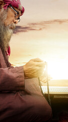 Poster - Muslim man with a beard wearing keffiyeh with agal praying with prayer beads on his hands