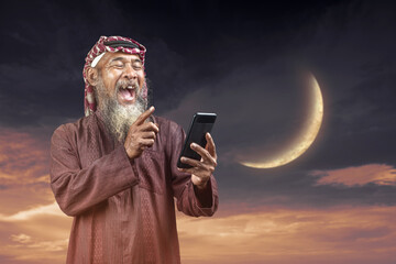 Poster - Muslim man with a beard wearing keffiyeh with agal using a mobile phone