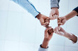 Business people, fist circle and teamwork in low angle, team building and trust in office. Solidarity, huddle and group or staff of men and women with hands together for unity, synergy or cooperation