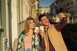 © DusanJelicic - tourists are taking photos using smart phone, holding a to go coffee in hand