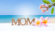 Mother's day card background idea, tropical style, mom wooden font with plumeria flower over summer beach background