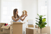 Moving House, Mortgage, Family And Real Estate Concept. Happy Asian Young Woman Inspecting Quality Stuff In Boxes Moving Into New House. Smiling Woman Checking Stuff In Cardboard Boxes