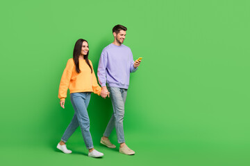Aufkleber - Full size profile portrait of attractive lady handsome guy use telephone hold hands walk empty space isolated on green color background