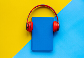 audiobook concept - book and headphones nearby. flat lay, top view