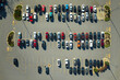 Aerial view of many colorful cars parked on parking lot with lines and markings for parking places and directions. Place for vehicles in front of a strip mall plaza