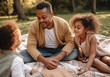 © LunaLu - Father with little daughters are relaxing in park. Happy father's day. African American family. Ai generated.