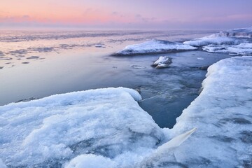 Sticker - Idyllic frozen rocky shore with pink sky on the horizon, perfect for wallpapers