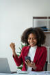 African american businesswoman working with laptop computer delighted with positive feedback on real estate project chatting online via mobile app sharing good news to colleague approved job.