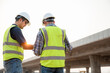 © เลิศลักษณ์ ทิพชัย - Rear view of road construction engineer with civil engineer to supervise new road construction and inspect construction site site.