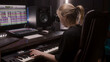 © Framestock - Female sound engineer, musician uses MIDI controller, digital electric piano for creating music. Computer screen shows DAW software interface with sound tracks. Recording studio. Music production.