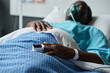 © AnnaStills - African American senior man with oxygen mask lying on bed in hospital ward