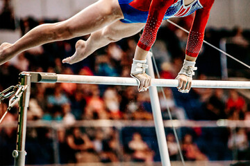 close-up body part female gymnast exercise on uneven bars in artistic gymnastics, sports summer games