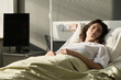 Young woman sleeping and resting on bed during her rehabilitation in hospital ward