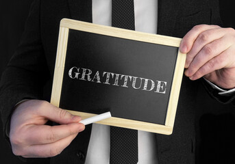 Poster - A businessman holds up a chalkboard with text Gratitude