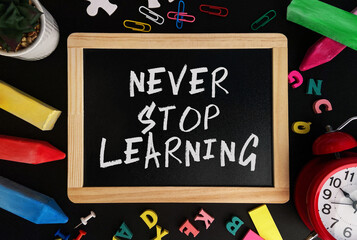 Aufkleber - Wooden board with Never Stop Learning text on a background of various colorful subjects