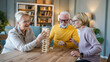 © Miljan Živković - Group of people senior man and women play leisure board game at home
